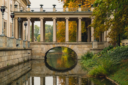 Baths classicist Palace on the Isle in Lazienki Park touristic place in Warsaw. Lazienki Royal Baths Park, Baroque columns Warsaw Poland. Colorful Autumn Foliage and Mirror Reflection on the Lake. Yellow leavesの写真素材