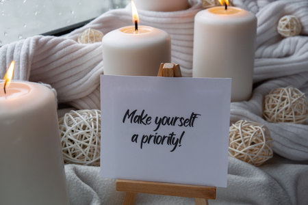 MAKE YOURSELF A PRIORITY text saying phrase on paper note on background of Home fragnance concept autumn holidays at cozy home. Still life of micro moment candid slow living. Mental health wellbeing exercises Raining Outside Hygge aestheticの写真素材