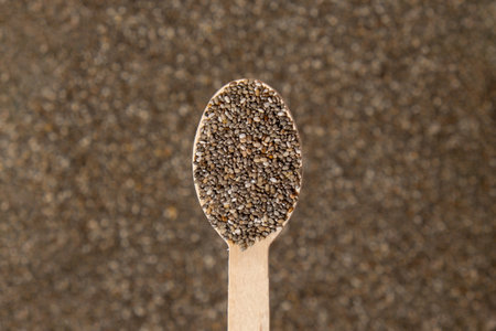 Chia seeds in wooden spoon. Healthy superfood rich in Omega 3 fatty acids. Dry healthy natural ingredient. Chia grains are fallingの写真素材