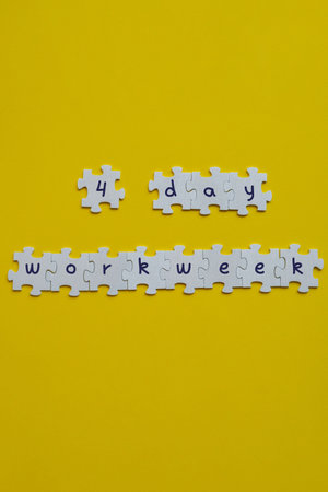 4 day work week symbol on puzzles four day working week concept. Modern approach doing business short workweek. Effectiveness of employees. Productivity and efficiencyの写真素材
