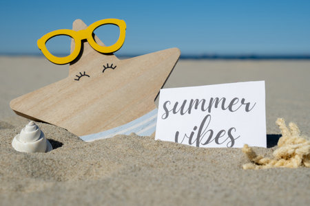 SUMMER VIBES text on paper greeting card on background of funny starfish in glasses summer vacation decor. Sandy beach sun coast. Holiday concept postcard. Getting away Travelの写真素材