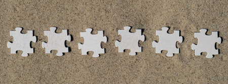 Six 6 wooden white puzzles copy space for your text on sandy beach. Summer vacation and holiday business travel concept. Jigsaw on the beach sand matching puzzle pieces together Template Mock up for sale promotion advertisementの写真素材