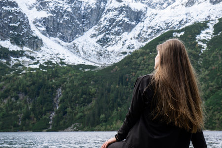 Young woman enjoying nature in Morskie Oko Snowy Mountain Hut in Polish Tatry mountains Zakopane Poland. Naturecore aesthetic beautiful green hills. Mental and physical wellbeing Travel outdoorsの写真素材