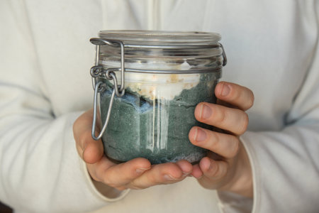 Unrecognizable woman eating Glass jar with natural organic homemade yogurt and blueberries spirulina chlorella superfood super powder blue algae sea weed. Immunity-boosting ingredients. Concept of healthy eating breakfast of Greek yogurt. Fermentingの写真素材