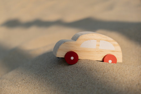 Wooden toy car on sandy beach background. Eco-friendly travel, reduce carbon footprints, environmental impact, Conscious Traveler, Environmentally Friendly, responsible traveler Eco-car concept World car free dayの写真素材