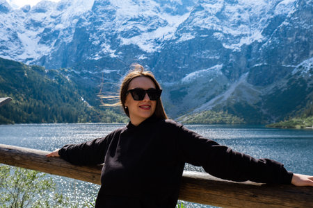 Young woman enjoying nature in Morskie Oko Snowy Mountain Hut in Polish Tatry mountains Zakopane Poland. Naturecore aesthetic beautiful green hills. Mental and physical wellbeing Travel outdoorsの写真素材