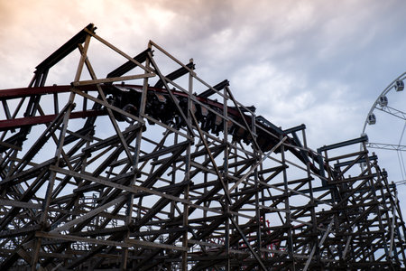 Riding the roller coaster at Energylandia Zator Poland amusement park. Solar powered roller coaster. Rollercoaster against blue sky Wooden outdoor leisure familyの写真素材