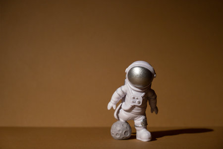 Plastic toy figure astronaut on beige neutral background Copy space. Concept of out of earth travel, private spaceman commercial flights missions and Sustainabilityの写真素材