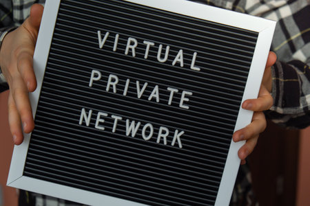 Female hand holding Letter board with text of VIRTUAL PRIVATE NETWORK VPN creation Internet...