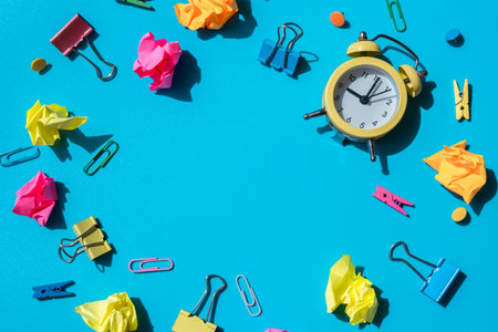 Frame border made of school stationery supplies and alarm clock. Copy space for your text or...