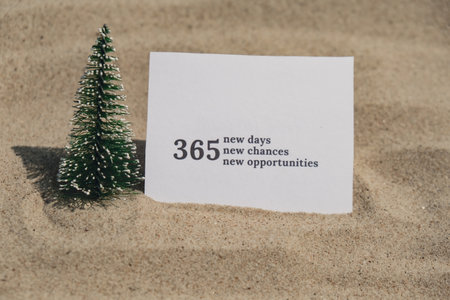 365 NEW DAYS CHANCES OPPORTUNITIES text on paper greeting card on background sandy beach sun coast. Christmas balls Santa hat New Year New Me Resolutions decoration. Summer vacation decor. Holiday concept calendar date postcard. Getting awayの写真素材