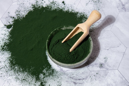 Blue-green algae Chlorella and spirulina powder in bowl with wooden spoon. Super powder. Natural...