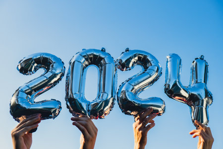Happy new year 2024 metallic balloons on blue sky background. Greeting card silver foil balloons numbers Christmas holiday concept. Celebration party congratulationの写真素材