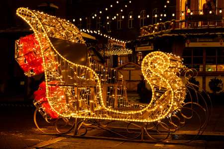 Santa Claus Sleigh Holiday Decorated and illuminated street at night in Gdansk Poland. Beautiful Christmas fair in the old town at night. Advent winter time in Europe background. Markets in December Ornamented for celebrationの写真素材
