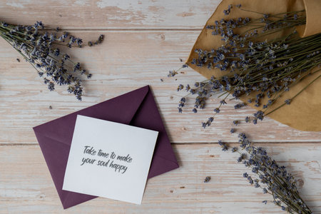 TAKE TIME TO MAKE YOUR SOUL HAPPY text on supportive message paper note reminder from green envelope. Flat lay composition dry lavender flowers. Concept of inner happiness, slowing-down digital detox personal fulfillmentの写真素材