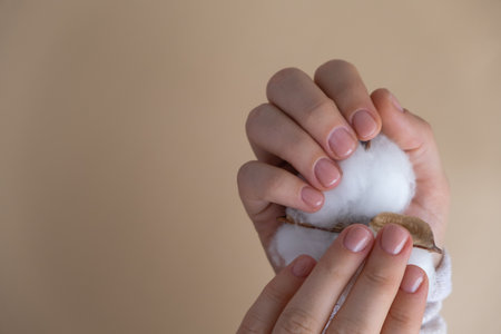 Pastel softness manicured nails on neutral beige background. Woman showing her new manicure in colors of pastel palette. Simplicity decor fresh spring vibes earth-colored neutral tonesの写真素材