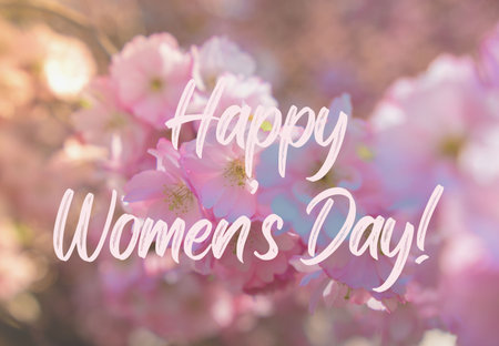 Greeting card text HAPPY WOMENS DAY saying Blooming sakura flowers natural background with copy space. Delicate pink flowers on the sakura tree close up. Floral Tender greeting card design. Sakura branchの写真素材