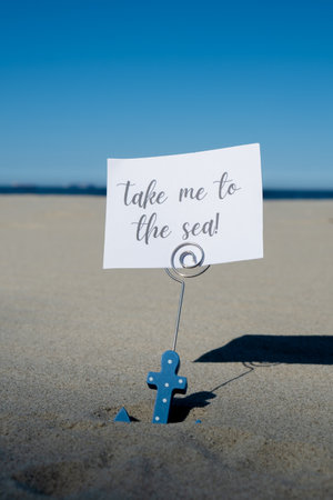 TAKE ME TO THE SEA text on paper greeting card in anchor paper holder and starfish seashell summer vacation decor. Sandy beach sun coast. Holiday concept postcard. Getting away Travel Business conceptの写真素材