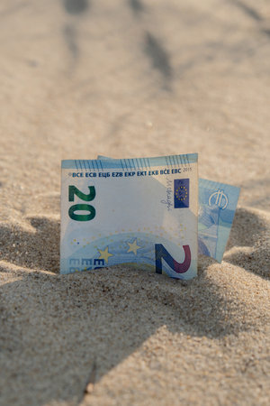 Money 20 euros bills in sandy beach. Concept finance saving money for holiday vacation. Costs in travel holidaysの写真素材