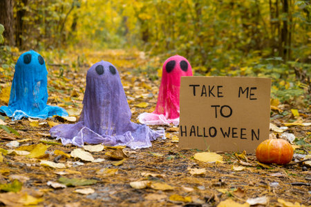 Trick or treat halloween colorful ghosts made of bandages in fall autumnal forest. Halloween...