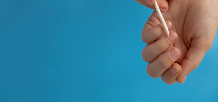 Pastel softness manicured nails on blue background. Mock up template copy space Woman showing her new manicure in colors of pastel palette. Simplicity decor fresh spring vibes earth-colored neutral tonesの写真素材
