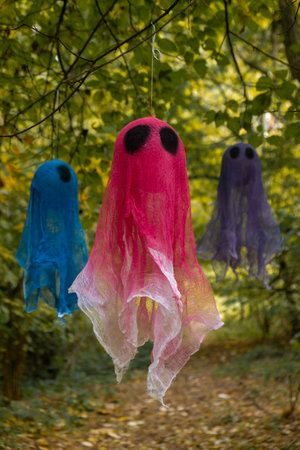 Trick or treat halloween colorful ghosts flying made of bandages in fall autumnal forest. Halloween greeting card. Handicraft handmade diyの写真素材