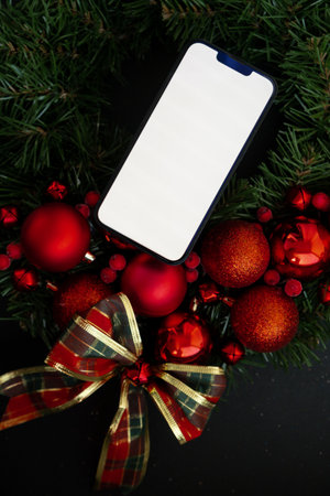 Smartphone mock up template white screen on handmade Christmas wreath. Zero waste eco-friendly Christmas. Sustainable greeting cardの写真素材