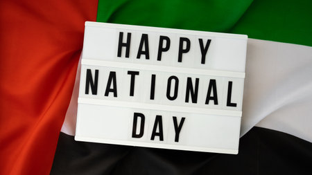 Lightbox HAPPY NATIONAL DAY text frame on United Arab Emirates waving flag made from silk material....