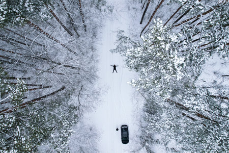 Aerial view beautiful snowy winter forest. Road in snow wintertime. Frosty morning travel concept background. Amazing winter scene. Spruce coveredの写真素材