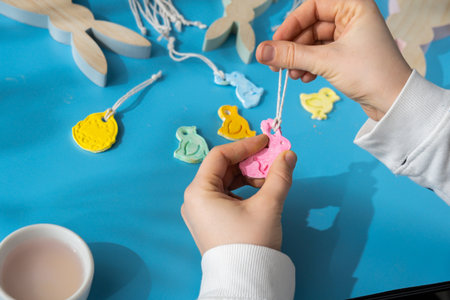 Unrecognizable artist do it yourself air dry clay crafts for Easter holiday. Decoration gift idea Handmade children craft. Step by step instruction of painting, pressing figuresの写真素材