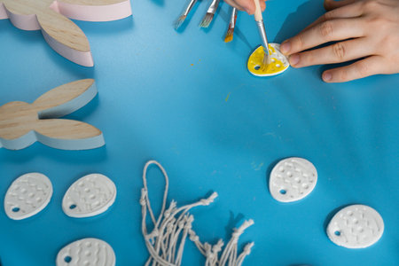 Unrecognizable artist do it yourself air dry clay crafts for Easter holiday. Decoration gift idea Handmade children craft. Step by step instruction of painting, pressing figuresの写真素材