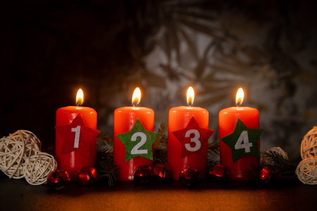 Traditional four advent weeks before Christmas holidays. Red candles with numbers burning in dark room and plastic free decoration. Copy space greeting card mock up template. Winter cozyの写真素材