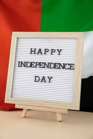 Text HAPPY INDEPENDENCE DAY on background waving flag of UAE. National holiday of United Arab Emirates. Dubaiの写真素材