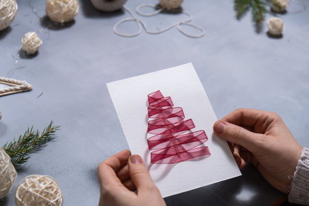 Christmas tree ribbon Storytelling of creating craft Christmas greeting card holiday present. Tactile hand-on activity. Master class progress of creative me-made gifts. Seasonal domestic life micro moment hobby. Sustainable livingの写真素材