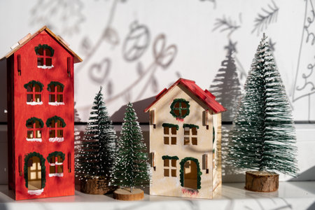 Craft wooden houses with candlelight for conscientious Merry Christmas decor. Sustainable celebration minimal responsible DIY holiday project. Festive modern decorationsの写真素材