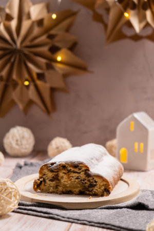 Homemade Christmas traditional cake pie with marzipan nuts and dried fruits pastry dessert stollen. Winter holidays season atmosphere. Delicious tasty composition home table settingの写真素材