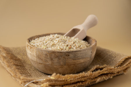 Brown rice in neutral beige background copy space. Whole spelt grain species. High protein fiber-rich vegan plant based food ingredient. Gluten free superfood healthy nutritional dietary alternativeの写真素材
