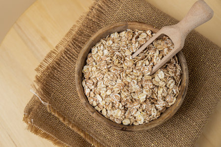 Raw oatmeal porridge in neutral beige background copy space. Whole spelt grain species. High protein fiber-rich vegan plant based food ingredient. Gluten free superfood healthy nutritional dietary alternativeの写真素材