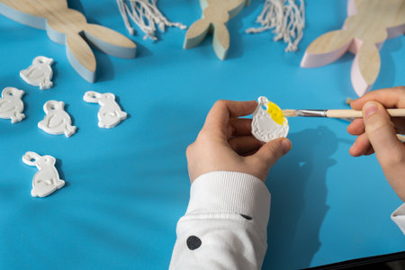 Master class of coloring Unrecognizable artist do it yourself air dry clay crafts for Easter holiday. Decoration gift idea Handmade children craft. Step by step instruction of painting, pressing figuresの写真素材