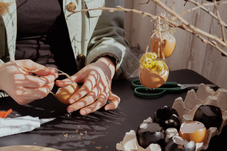Unrecognizable woman creating Easter holiday decoration from egg shell. Diy do it yourself step by step instruction. Crafting preparationの写真素材