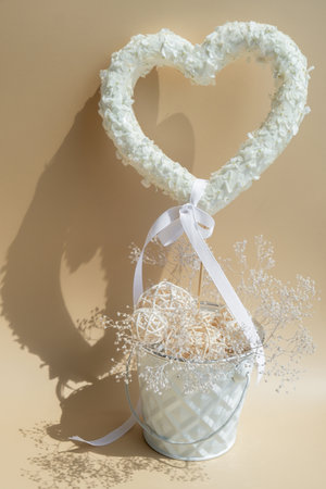 White lilac flowers heart shaped decor for present gift in pastel backdrop. Symbol of love floral arrangement. Spring concept idea Valentines Day, wedding proposal postcard copy spaceの写真素材
