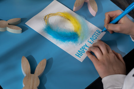 Creating Easter egg with cotton rope and colorful feather Storytelling of creating craft Easter greeting card holiday present. Tactile hand-on activity. Master class progress of creative me-made gifts. Seasonal domestic life micro moment hobbyの写真素材