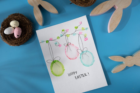 Handmade greeting card with EASTER eggs HAPPY EASTER written in beautiful handwriting. Gesture shows...