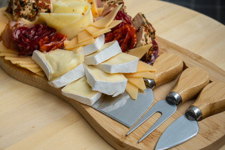 Food trend gift aperitivo party idea. Appetizers wooden grazing board with different antipasti charcuterie snacks and cheese. Assorted cheese meat platter.の写真素材