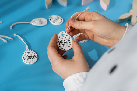 Master class word PEACE on EASTER clay egg Creator is using white air dry clay for making decor to EASTER holiday. Creating hobby recreation activity that involves fingers. DIY craftingの写真素材