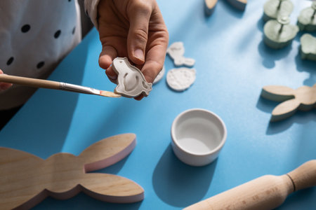 Master class of painting Creator is using white air dry clay for making decor to EASTER holiday. Creating hobby recreation activity that involves fingers. DIY craftingの写真素材