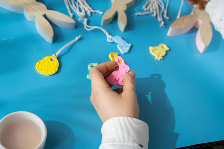Unrecognizable artist do it yourself air dry clay crafts for Easter holiday. Decoration gift idea Handmade children craft. Step by step instruction of painting, pressing figuresの写真素材