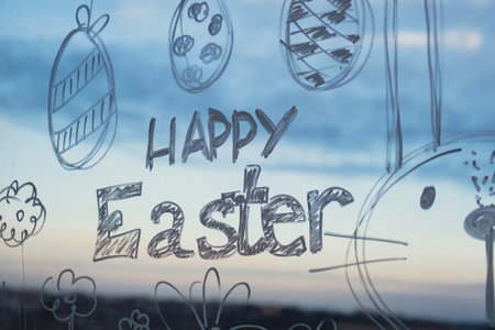 HAPPY EASTER message Zero cost responsible holiday decor economically driven. Painted Easter bunny rabbit on window glass indoor at home. Affordable alternative Easter springtime seasonal tradition ideas decorationの写真素材