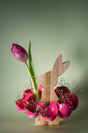 Creative vibrant handmade Easter table decoration with egg shells wooden bunny on pastel green background copy space. Greeting card idea Easter home tradition Seasonal sustainableの写真素材
