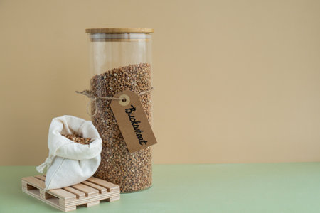 Raw buckwheat porridge in sustainable natural packaging. Refillable systems. Gluten free cereals. Health gut benefits. Concept of alternative whole spelt grain ingredient. Vegetarian diet recipes. Plant-based lifestyle. Copy space Protein richの写真素材